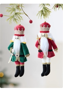 Close-up of plush Nutcracker soldier ornaments with gold glitter crowns on a Christmas tree