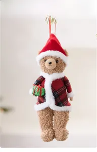 Close-up of plush brown Christmas teddy bear hanging ornament with festive red plaid jacket