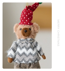 Detailed close-up of cute Christmas bear plush ornament with red knit hat and sweater