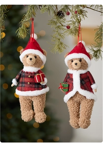 Close-up of plush Christmas teddy bear ornaments with red plaid outfits on pine branches