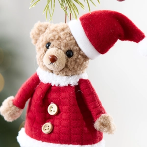 Süßer brauner Plüschbär mit Weihnachtsmütze und roter Jacke als Weihnachtsdeko