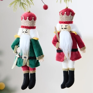 Set of two velvet Nutcracker soldier Christmas ornaments hanging on a festive pine branch
