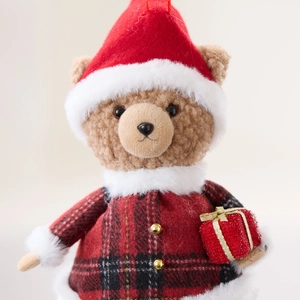 Christmas plush teddy bear ornament in red plaid coat holding a glitter gift box