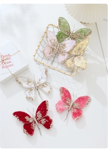 Close-up of colorful velvet butterfly clips with gold glitter edges for Christmas tree