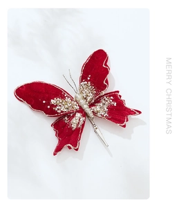 Close-up of red velvet Christmas butterfly ornament with gold sequins and metal clip