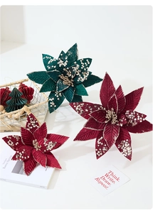 Close-up of velvet Christmas poinsettias with sequins and vintage decorative props