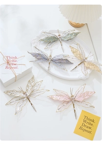 Close-up of glitter-edged mesh butterfly clips with beads and metal crocodile base