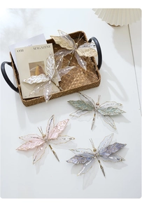 Detail of four butterfly clips with sheer fabric and sequins for wedding decor