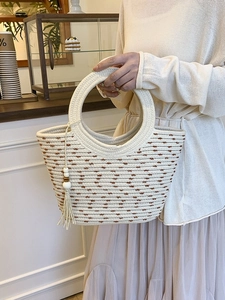 Chic cream straw tote bag with brown polka dots and a stylish round handle for summer