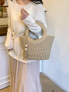 Handmade beige straw tote bag with black dots and decorative wooden bead tassel