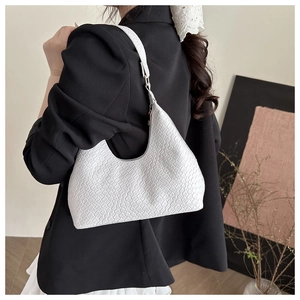 Detail of white woven texture leather hobo bag worn by model over the shoulder