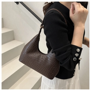 Detail shot of a dark brown woven leather hobo bag featuring intricate braided texture