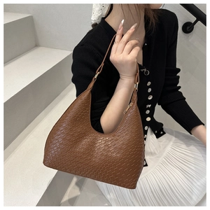 Brown crocodile pattern faux leather hobo shoulder bag shown on model with casual outfit