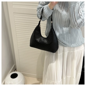 Detail of black woven leather hobo shoulder bag with elegant gold zipper and sleek strap