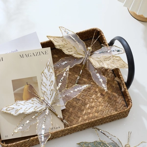 Elegant velvet mesh butterfly ornaments with gold veins on a rustic rattan tray