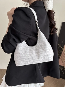 White woven texture hobo bag styled with a black blazer for a modern minimalist look