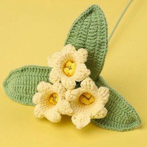 Bouquet de marguerites tricoté main avec feuilles vertes sur fond jaune chaleureux
