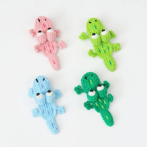 Détail de quatre barrettes crocodiles en crochet fait main aux tons rose et vert