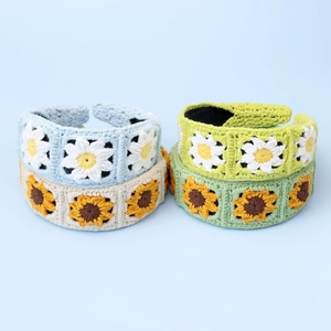 Detailed texture of handmade crochet floral headbands with sunflower and daisy patterns