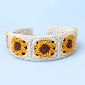 Detail of handmade crochet sunflower headband with intricate floral knit patterns