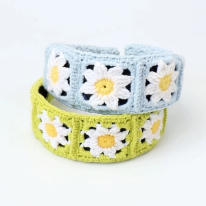 Detail of handmade crocheted daisy headbands in light blue and green wool texture