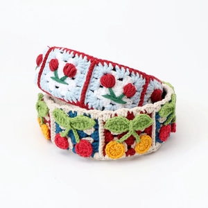 Close-up of hand-knitted crochet hair clips with vibrant cherry patterns and textures