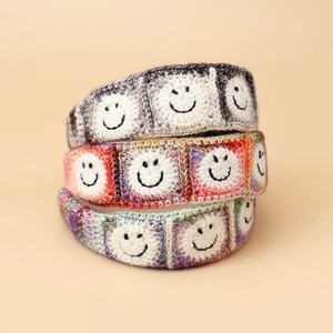 Detail of colorful knitted headbands featuring hand-stitched smiley face embroidery