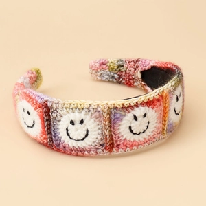 Macro shot of colorful crochet headband featuring cute black smiley face embroidery