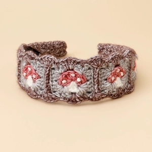 Detail of handmade crochet hairband featuring mushroom embroidery and granny squares