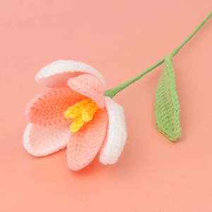 Close-up of handmade crochet tulip with white and pink petals showing fine knit texture