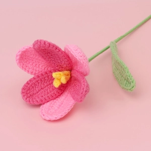 Detailed macro view of handmade crochet tulip with pink gradient yarn and yellow stamens