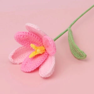 Detailed macro shot of handmade crochet gradient pink tulip with fine yarn texture