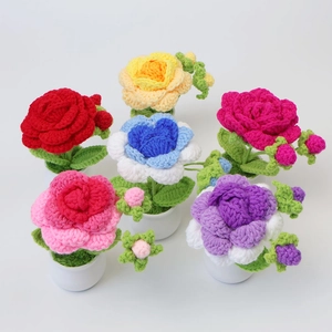 Overhead view of six colorful crochet rose potted plants for desktop decor and gifts