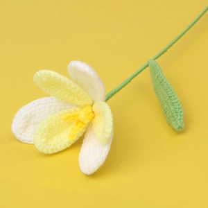 Detail of handmade crochet tulip with white and yellow gradient petals and green stem
