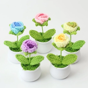 Detail of five handmade crochet rose mini potted plants in pastel colors for desk decor