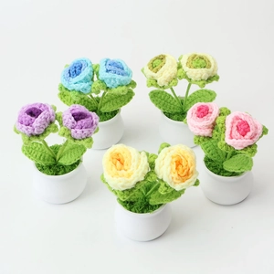 Close-up of five handmade crochet rose potted plants in various pastel colors on white