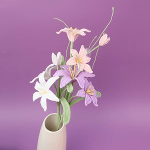 Detailed close-up of handmade crochet lily bouquet in a ceramic vase with soft lighting