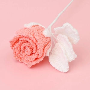Detail eines rosa gehäkelten Rosenstraußes mit weißen Blättern und Stielen