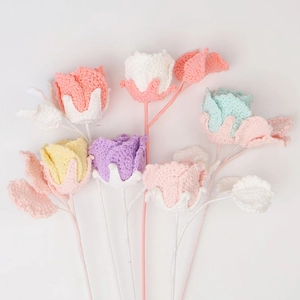 Nahaufnahme handgehäkelter Rosen in Makronenfarben mit feiner Stricktextur