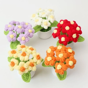 Close-up of five colorful handmade crochet puff flower pots on a white background
