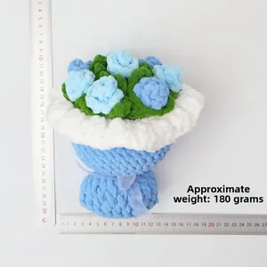 Handmade crochet bouquet with blue roses and green leaves on white background