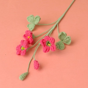 Dettaglio di bouquet di trifoglio fatto a mano all'uncinetto con fiori rosa e filato intrecciato