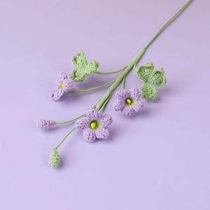 Vista macro di tre fiori di trifoglio viola all'uncinetto con stami gialli e steli verdi