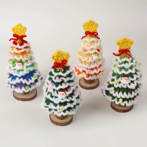 Handmade crochet Christmas tree set with bells and wooden base on white background