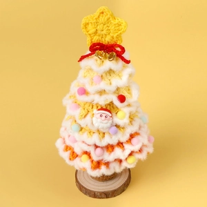 Detail of crochet Christmas tree with Santa charm and bells on wooden base