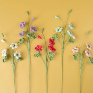 Bouquet di trifoglio fatto a mano all'uncinetto con cinque steli di fiori su sfondo giallo