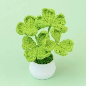 Handmade crochet green four-leaf clover potted plant with a white ceramic base