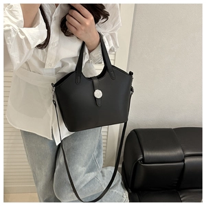 Detail einer schwarzen Beuteltasche mit Silberschnalle und dünnem Riemen im Lifestyle-Look