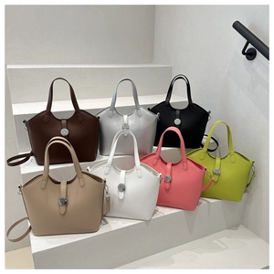 Collection of minimalist leather tote bags in seven colors displayed on white steps