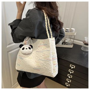 Detailed view of woven canvas tote bag with multi-colored wavy embroidery and panda charm